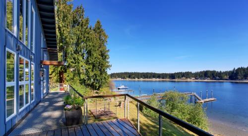 Blue house with wooden deck overlooking a lake