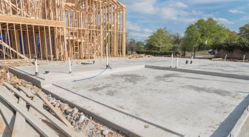 Exposed slab foundation with framed portion of home in background