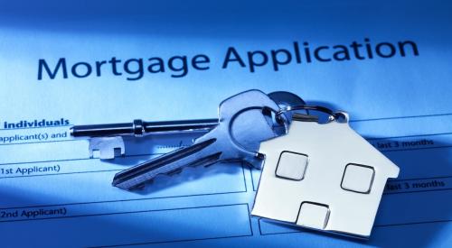 Mortgage application with house key on top of it