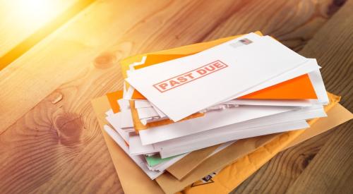 Pile of past due bills on wooden table