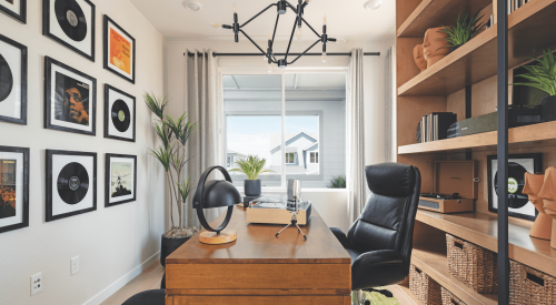 Spacious home office with floor-to-ceiling bookshelves and a wood desk