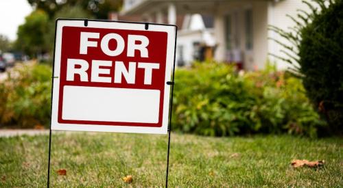 A "For Rent" sign sits in front of a single-family home. 