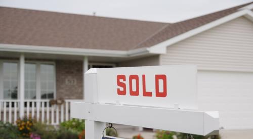 A single-story home with a sign reading "sold" on the front lawn