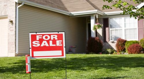 A starter home with a "for sale" sign outside on the front lawn