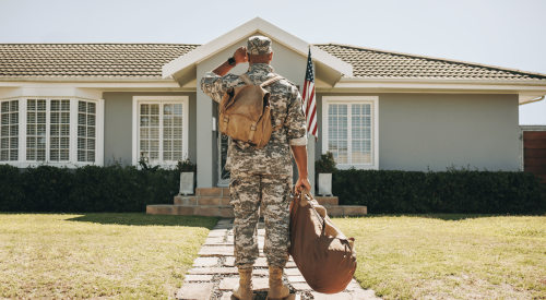 U.S. Army veteran stands outside home looking at front door