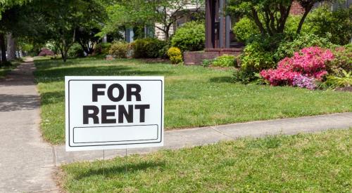 A "For Rent" sign posted in a front yard 