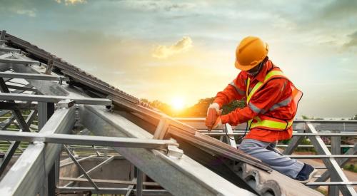 A construction worker works on a roof