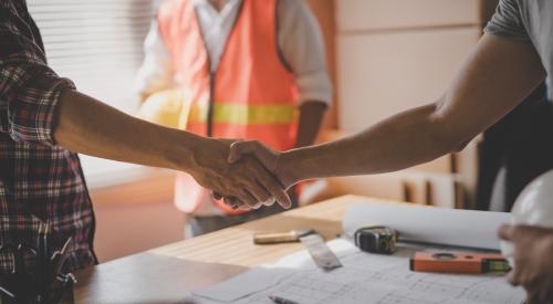 A worker and a homeowner shake hands, negotiating a job.