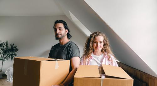 Happy couple unpacking boxes in new home