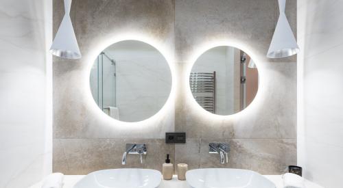 Twin bathroom mirrors with lighting around the back