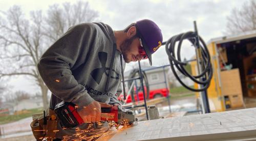 Student cutting wood for residential house construction