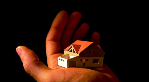 House model in the palm of a man's hand