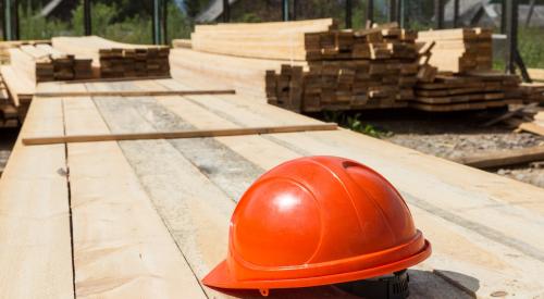 Orange hardhat in a lumber yard