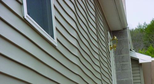 Buckled sheathing on house exterior wall