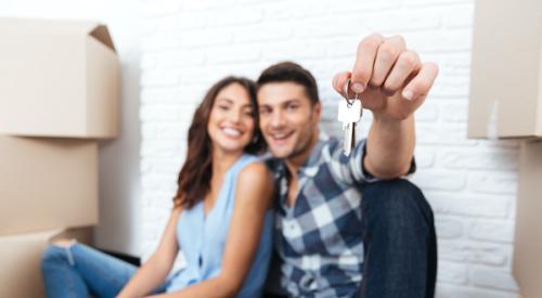 Two smiling new homeowners with house keys