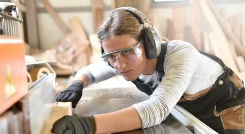 Woman using tool to cut wood