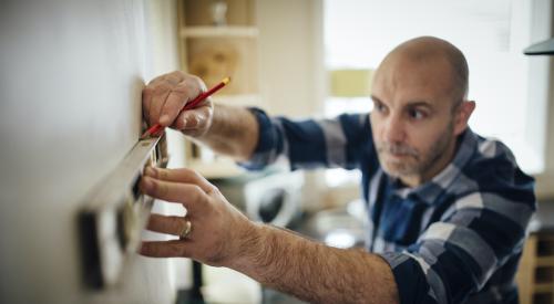 Man marking wall for DIY