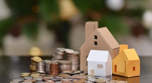 Paper houses with stacks of coins