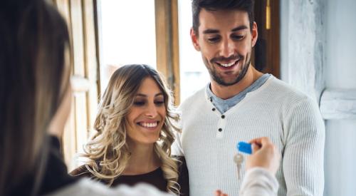 Smiling couple receiving keys to their new home