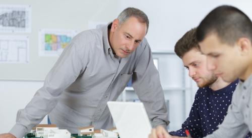 Teacher observing architecture students