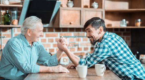 Older man and younger man arm wrestling