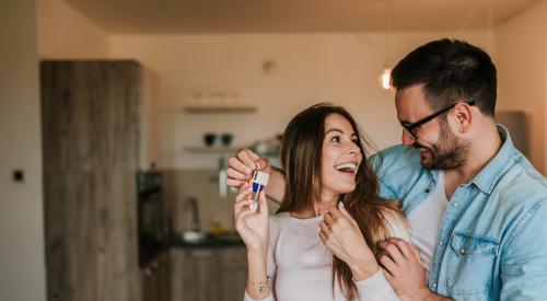 Two people smiling with house keys