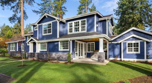 Large blue home with green grass