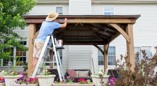 Man staining his gazebo