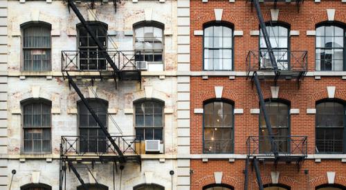 Exterior of two brick New York City apartment buildings with fire escapes