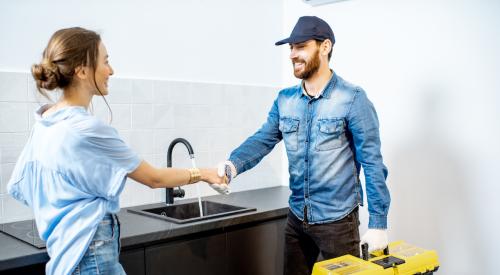 Woman shaking plumber's hand