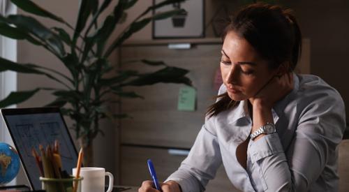 Woman sitting at desk filling out paperwork