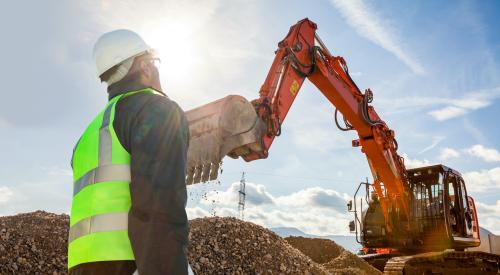 Construction worker observing excavation