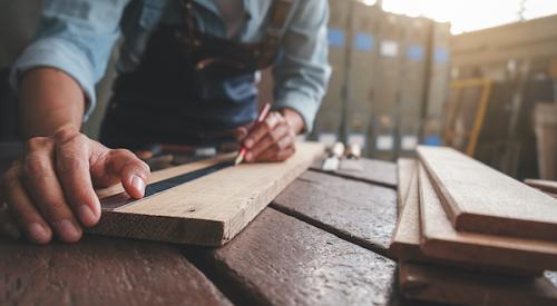 Worker measuring lumber