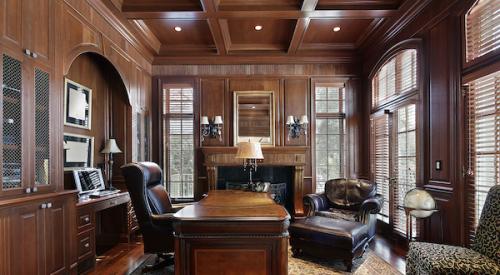 Wood-paneled home office with leather chairs and heavy wood desk