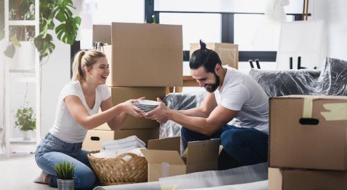 Couple laughing as they pack moving boxes