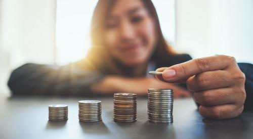 Young woman stacking coins