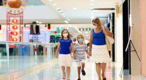 Mother and children wearing masks while walking through mall