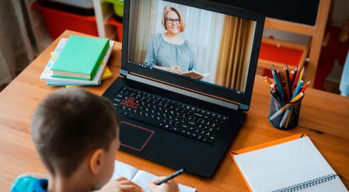 Child taking notes while watching virtual lesson