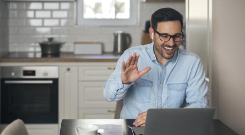 Man smiling and waving to webinar