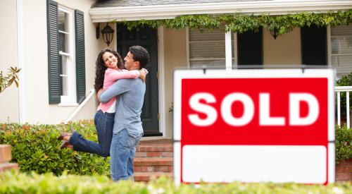 Smiling couple with sold house