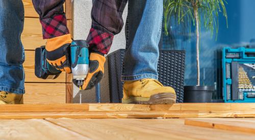 Worker drilling wooden planks