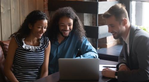 Couple and realtor smiling at laptop