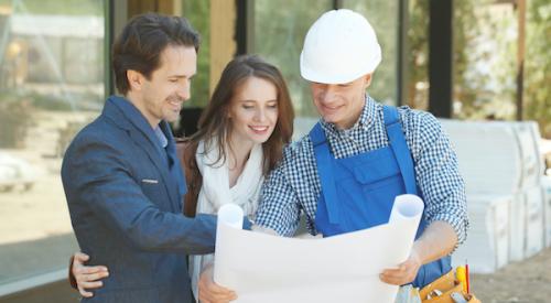 Builder smiling and showing plans to smiling clients