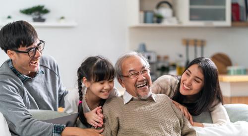 Multiple generations of one family laughing on the couch together