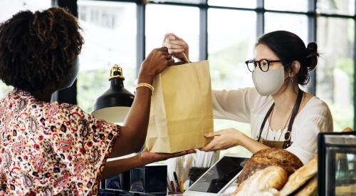 Cashier handing customer a bag