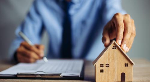 Businessman holding a house