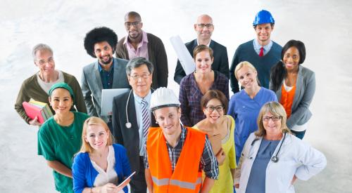 A group of people in different lines of work stand in a circle, looking up at the camera.