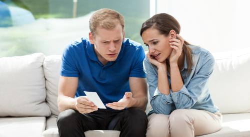 Unhappy couple looking at high bill