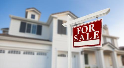 Home with for sale sign in forefront