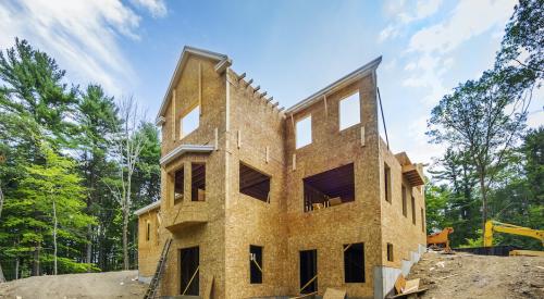 Single-family home construction site with framing almost complete